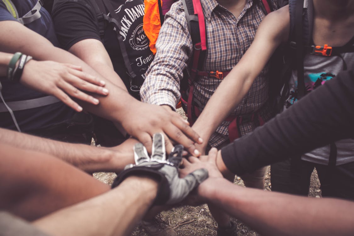 Groupe de personnes joignant leurs mains en cercle, esprit d'équipe et cohésion associative