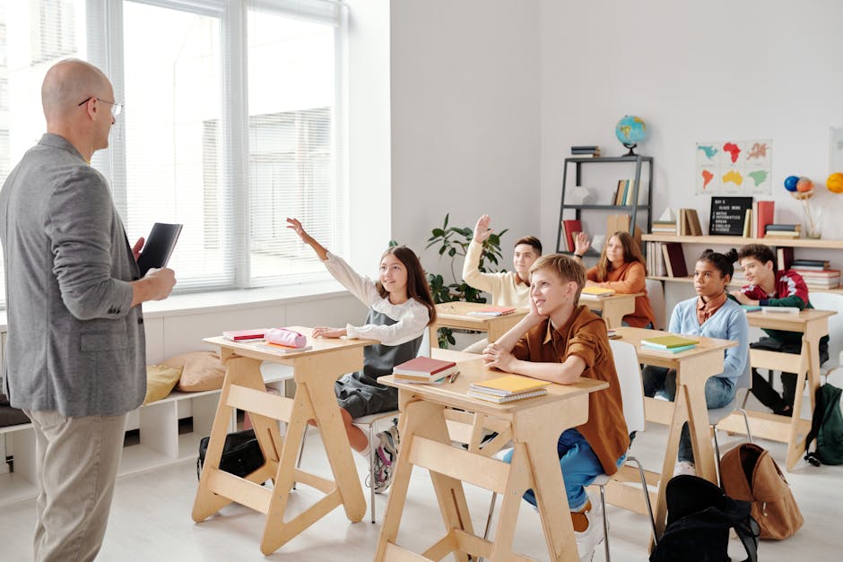 Élèves levant la main en classe avec enthousiasme